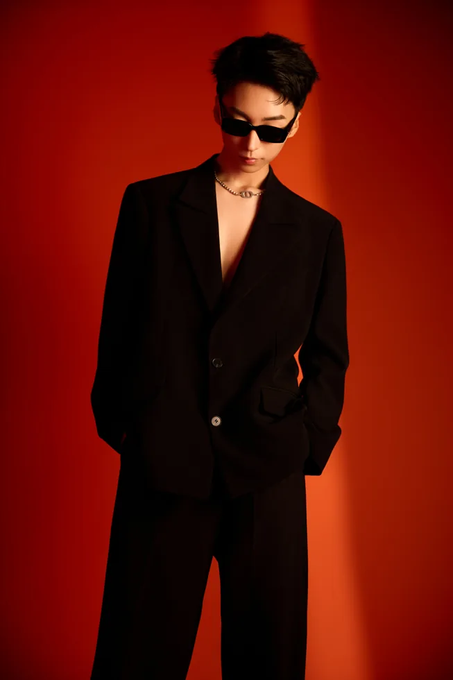 Black suit and sunglasses portrait of Z·GY against red